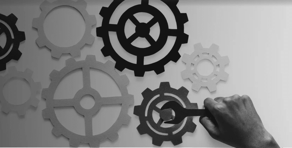 hand fixing gears depicting maintenance strategy fixing maintenance issues