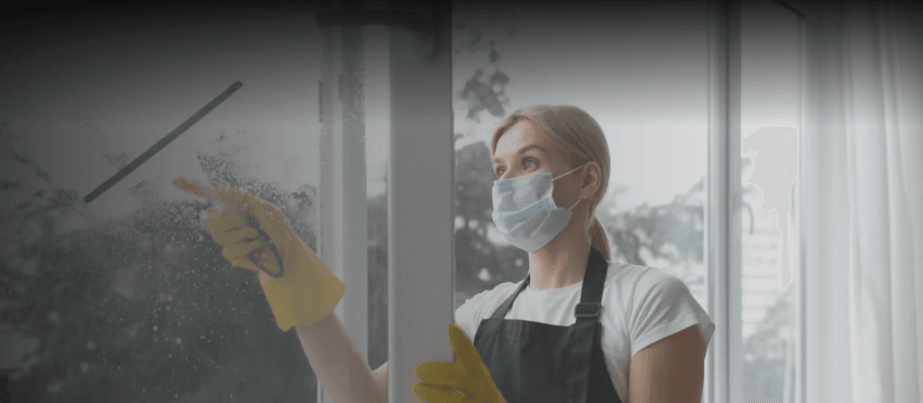 Person cleaning office window as a part of soft service FM