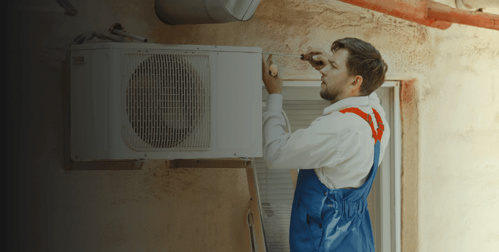 Technician performing HVAC maintenance on a ventilation unit.
